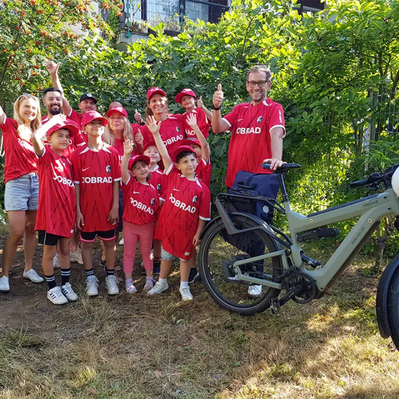 JobRad-Gründer Uli Prediger liefert die neuen SC-Trikots an Freiburg packt an