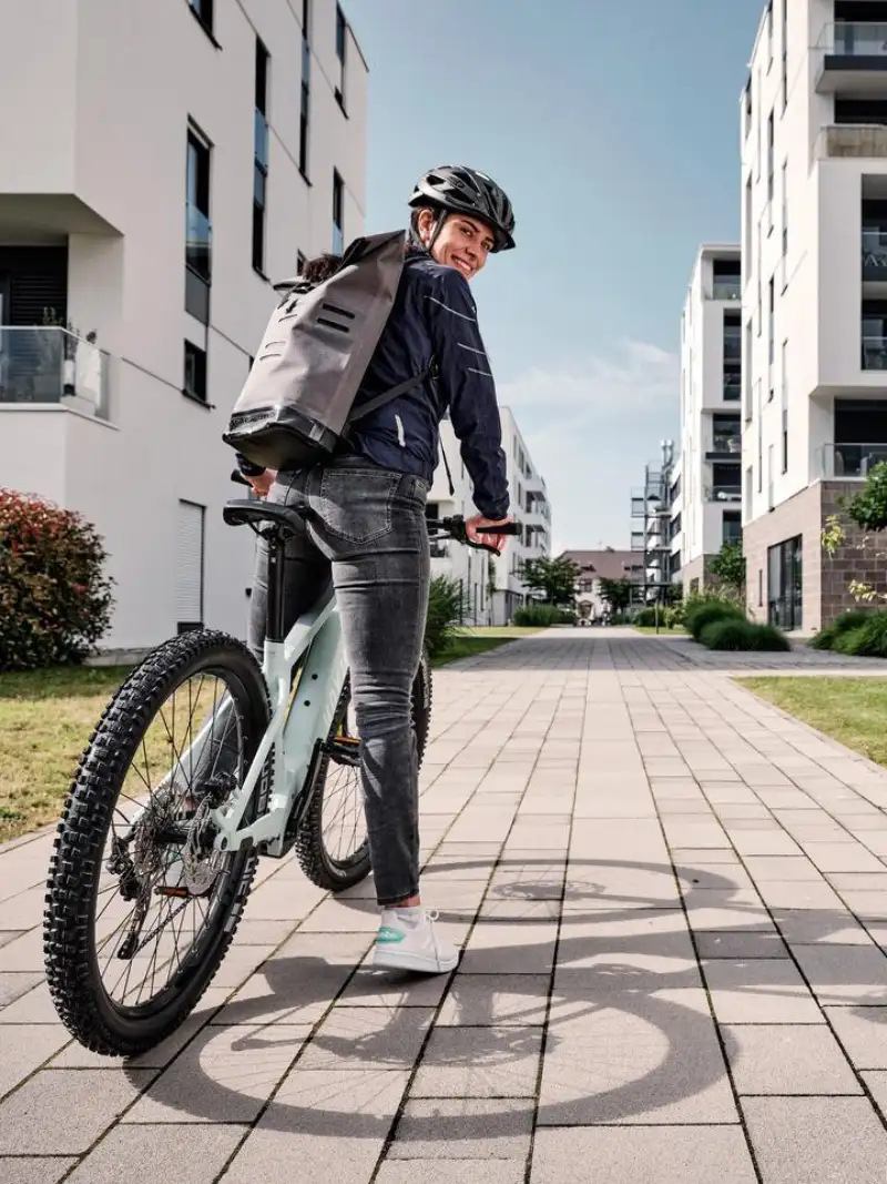 JobRadlerin mit Mountainbike in einer Häuserschlucht